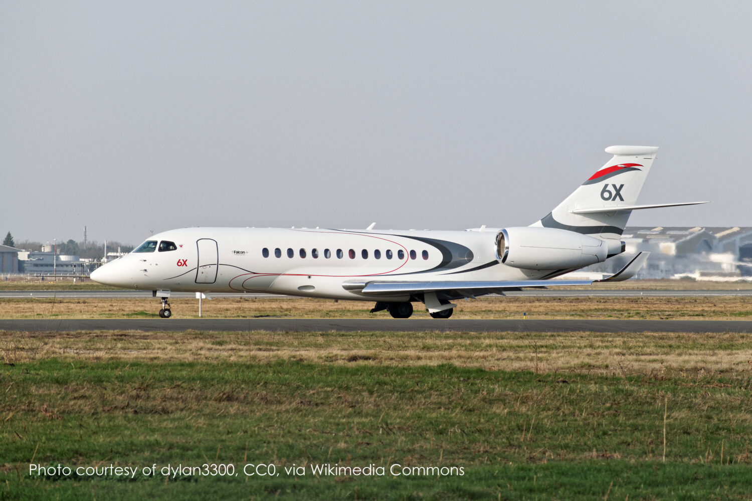 Falcon 6X business jet taxiing on an airport runway, showcasing sleek design and advanced aerodynamics essential for luxury travel.